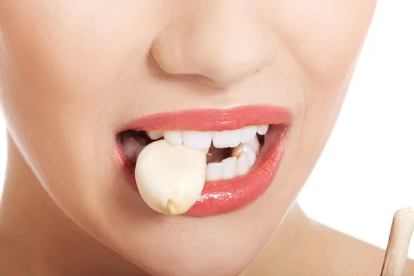 Woman mouth eating garlic — Stock Photo, Image