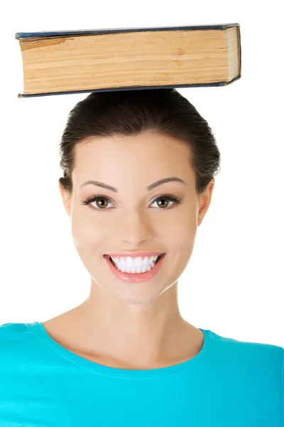Woman holding book on her head — Stock Photo, Image