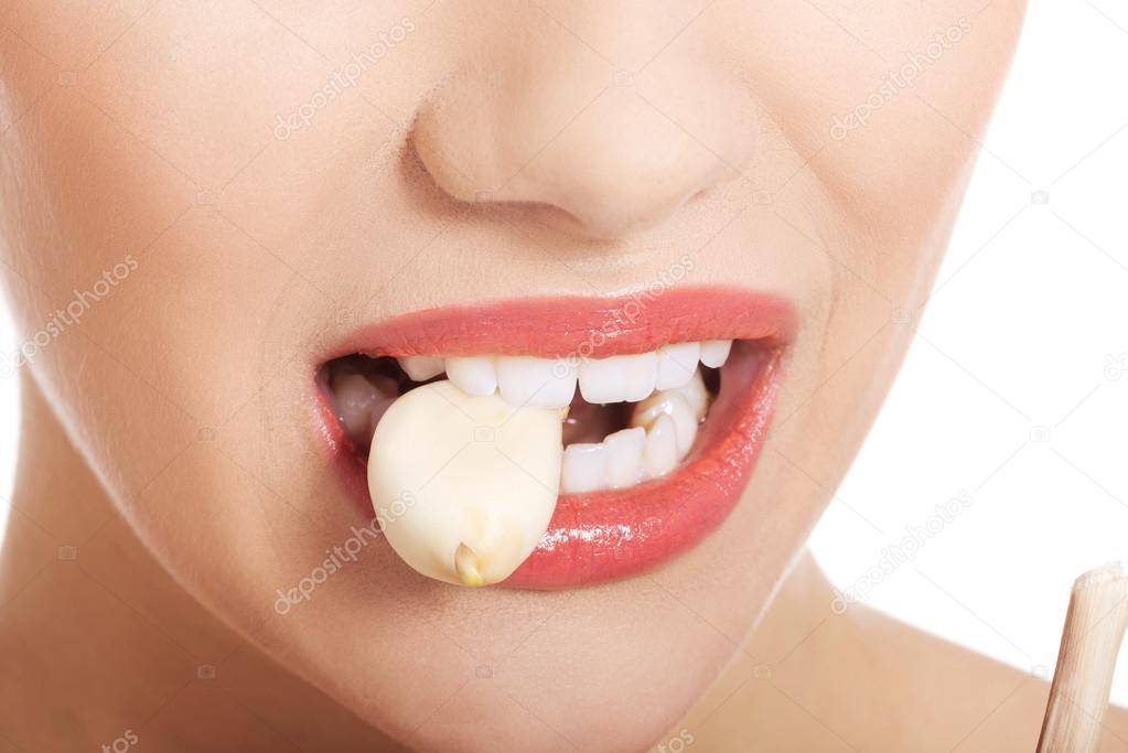 Woman mouth eating garlic