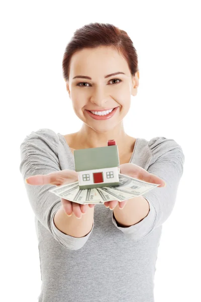 Mujer feliz sosteniendo modelo de casa y billetes de dólar —  Fotos de Stock