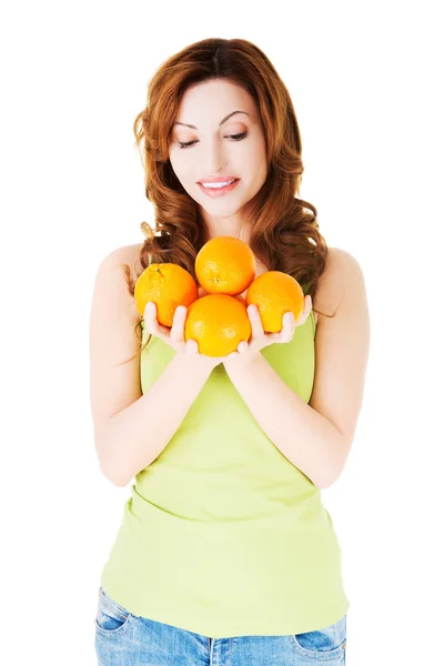 Happy woman holding oranges — Stock Photo, Image