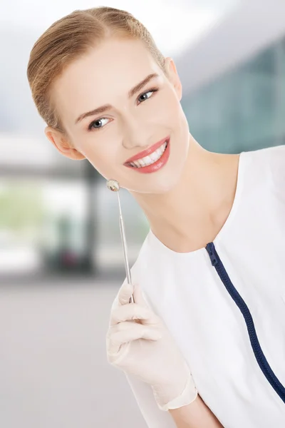 Jovem dentista com pequeno espelho para verificar os dentes . — Fotografia de Stock