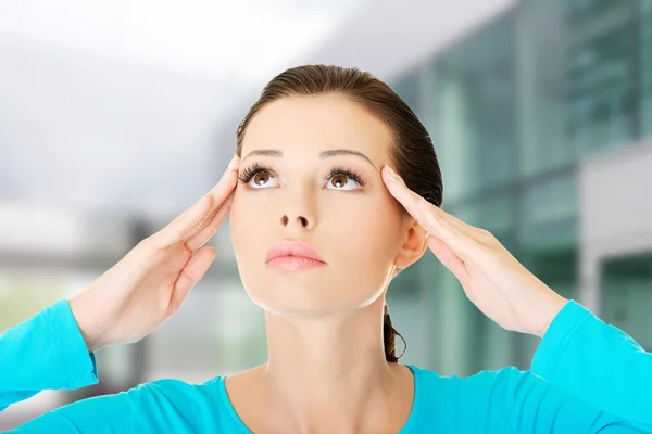 Mooie casual vrouw aanraken haar tempels. — Stockfoto