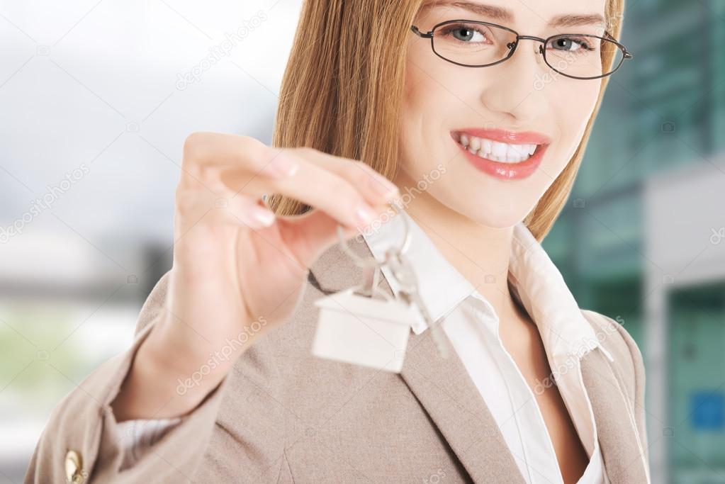 Caucasian business woman holds home keys.