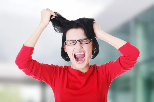 Mulher estressada está ficando louca puxando o cabelo . — Fotografia de Stock