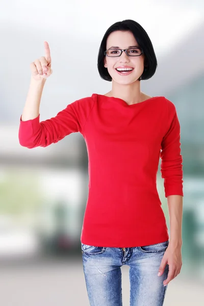 Excited young woman pointing on copy space — Stock Photo, Image