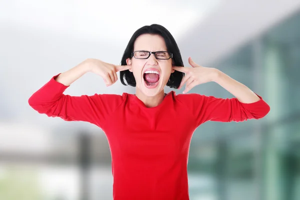 Frustrierte junge Frau hält sich die Ohren zu — Stockfoto