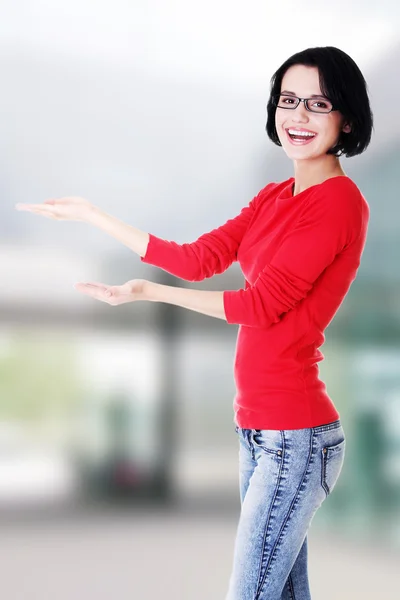 Heureuse jeune femme pointant sur l'espace de copie — Photo