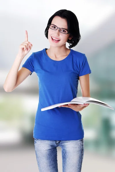 Studium der glücklichen jungen Frau beim Lesen ihres Notizbuchs — Stockfoto