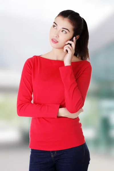 Ung kvinna som ringer med en mobiltelefon — Stockfoto