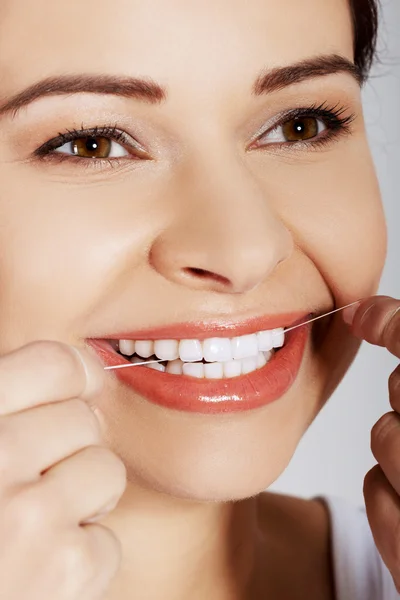 Retrato de mujer limpiando dientes con hilo dental — Foto de Stock