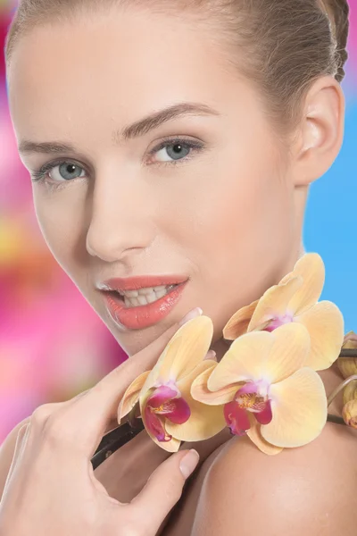 Bella donna con un fiore di orchidea — Foto Stock