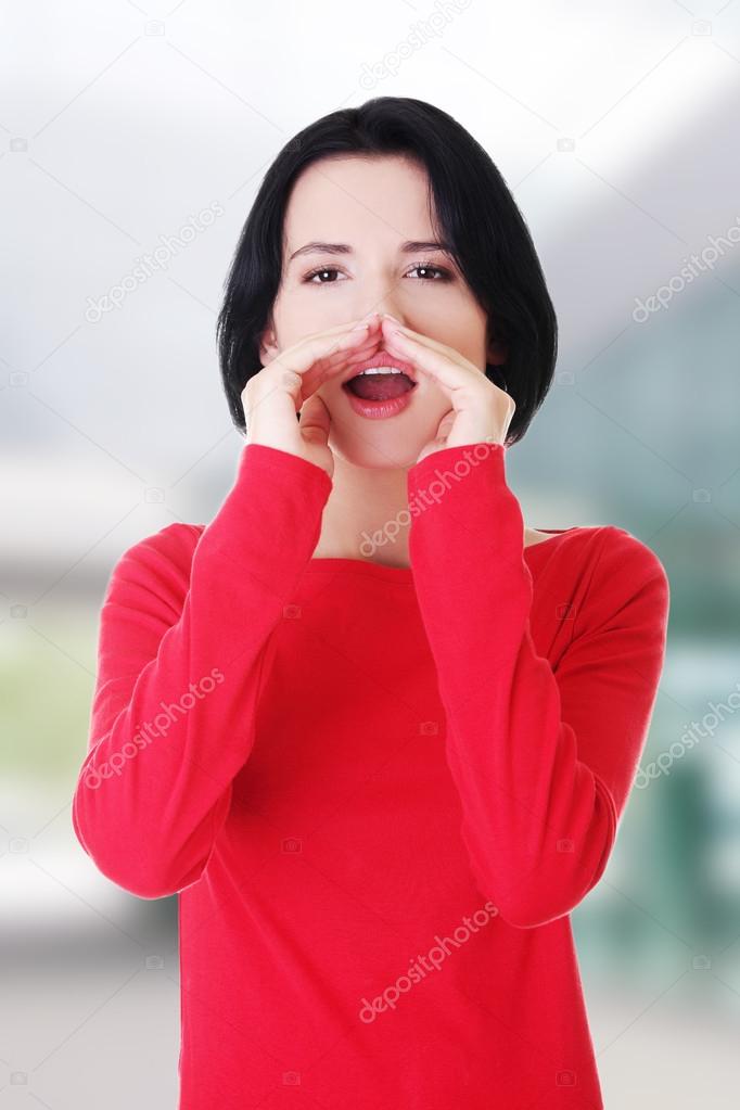 Pretty caucasian woman whispering gossip.