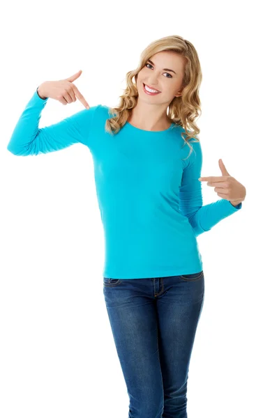 Lächelnde Frau zeigt auf ihr Hemd — Stockfoto