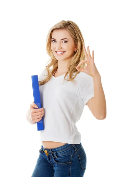 Young woman making ok sign holding binder — Stock Photo, Image