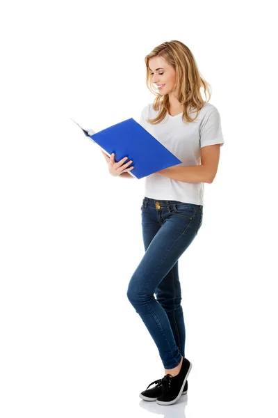 Ung kvinna läsa anteckningar i hennes pärm — Stockfoto