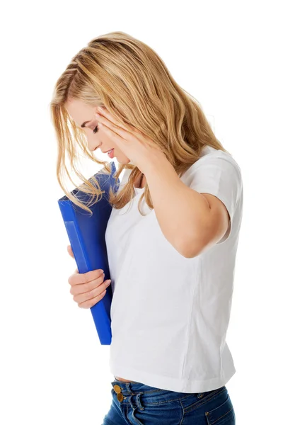 Side view of woman with headache holding a binder — Stock Photo, Image