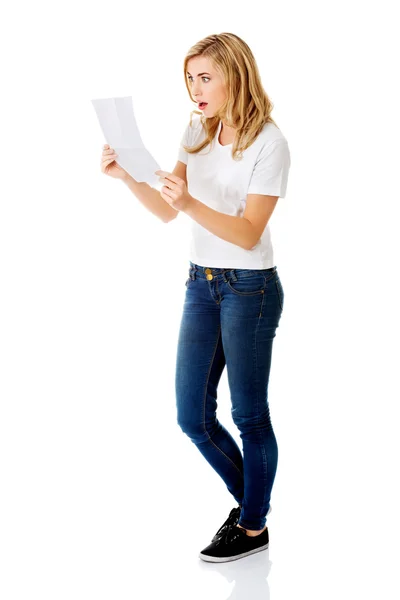 Überraschte junge Frau beim Lesen einiger Notizen — Stockfoto