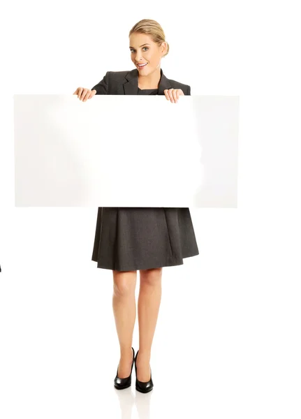 Businesswoman holding empty billboard — Stock Photo, Image