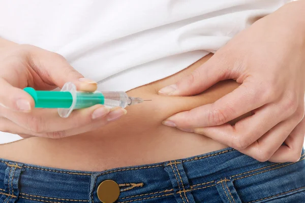 Woman injecting her belly — Stock Photo, Image