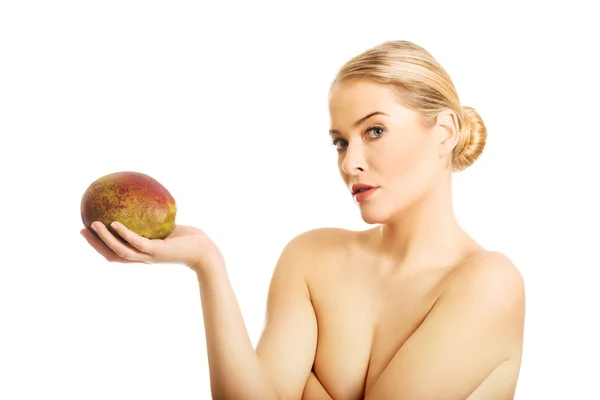 Donna nuda con un mango in mano — Foto Stock