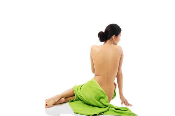 Bakifrån kvinna sitter insvept i handduk — Stockfoto