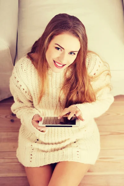 Mooie Kaukasische vrouw zittend op de vloer met Tablet PC. — Stockfoto