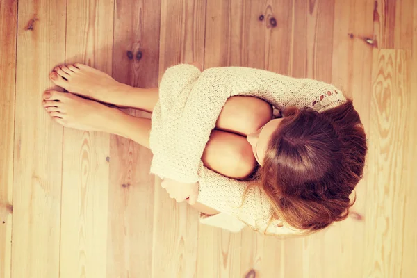 Mooie Kaukasische vrouw is zittend op de vloer. — Stockfoto