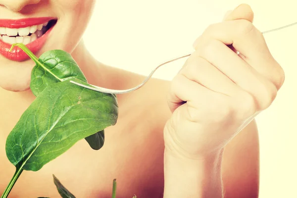 Hermosa mujer caucásica comiendo luttce verde fresco de un tazón — Foto de Stock