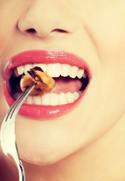 Sonriente mujer caucásica comiendo fruta de mar con tenedor . — Foto de Stock