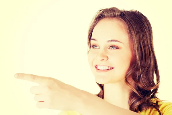 Blij, opgewonden jonge vrouw wijzend op kopie ruimte — Stockfoto