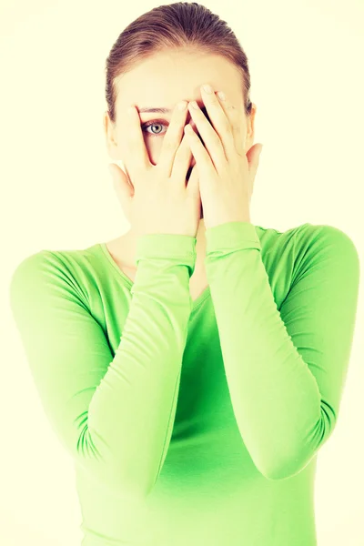 Attractive woman covering her face with both hands. — Stock Photo, Image