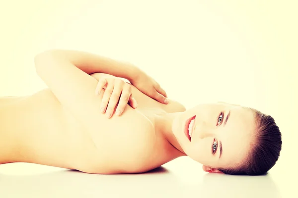 Atraktivní nahá žena leží na podlaze, při pohledu na fotoaparát. — Stock fotografie
