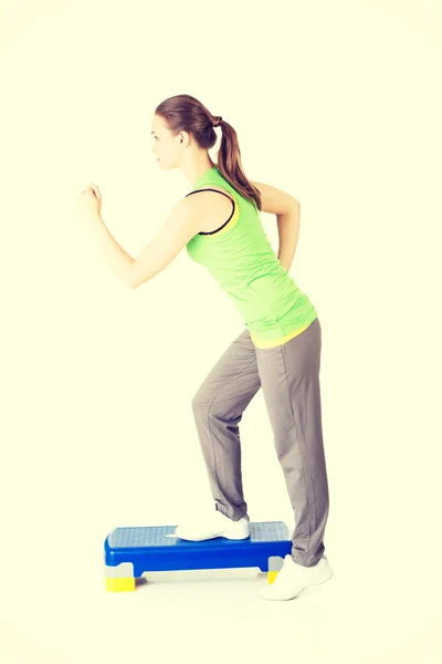 Fitness girl is working out with stepper — Stock Photo, Image