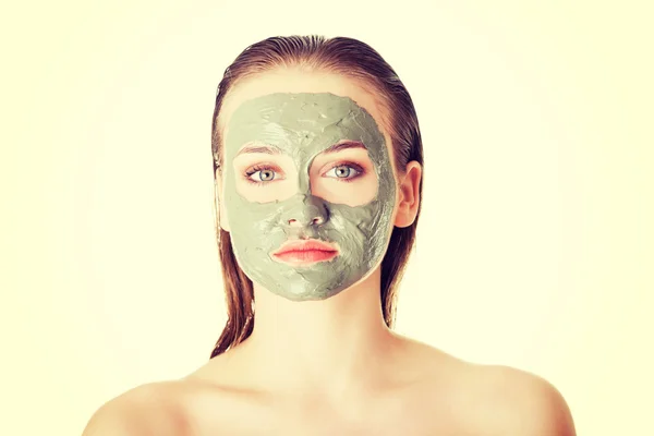 Beautiful woman with clay facial mask, isolated on white — Stock Photo, Image