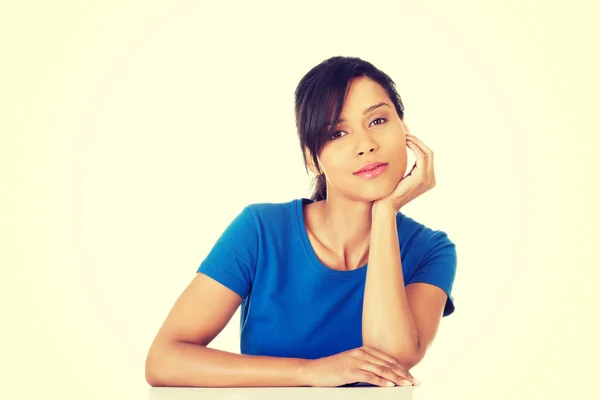 Pretty, happy, young woman in casual clothes sitting at the desk — Stock Photo, Image