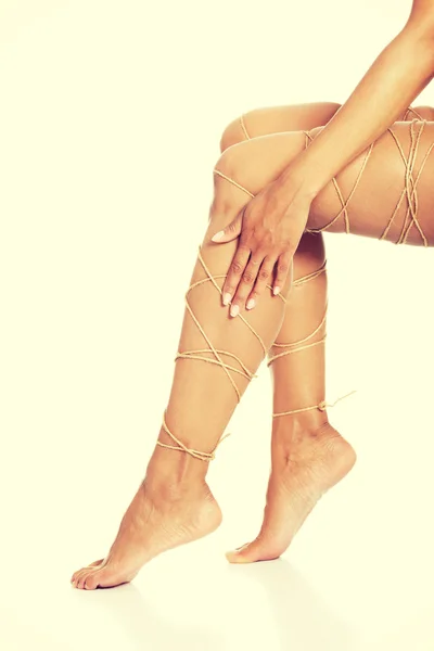 Концепция болей в ногах - ноги связаны веревкой — стоковое фото
