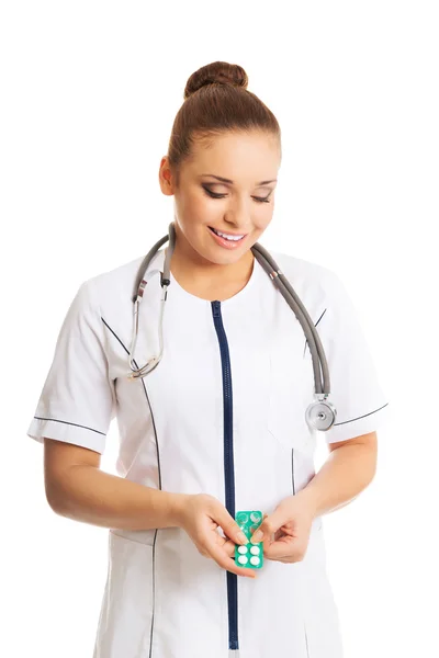 Счастливая женщина-врач держит таблетки — стоковое фото