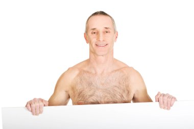 Mutlu olgun gömleksiz adam boş afiş tutarak