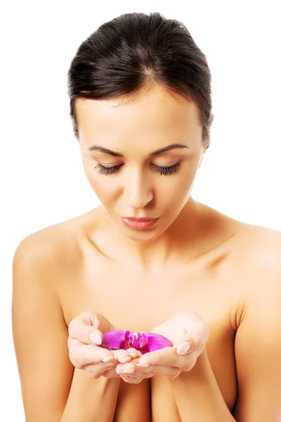 Mujer desnuda sosteniendo orquídea púrpura — Foto de Stock