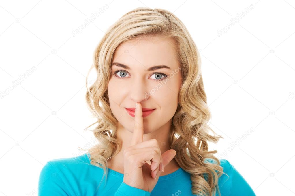 Portrait of a woman making silence gesture