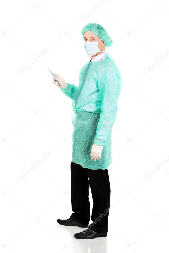 Full length side view male doctor with a scalpel