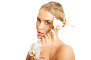 Beyaz Orkide çiçek tutan güzel çıplak kadın