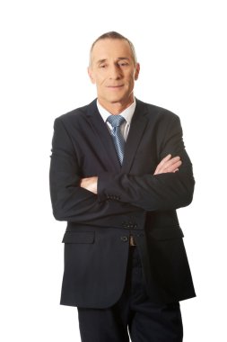 Katlanmış silah ile ayakta olgun iş adamı