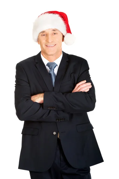 Empresário com braços dobrados usando chapéu de Papai Noel — Fotografia de Stock