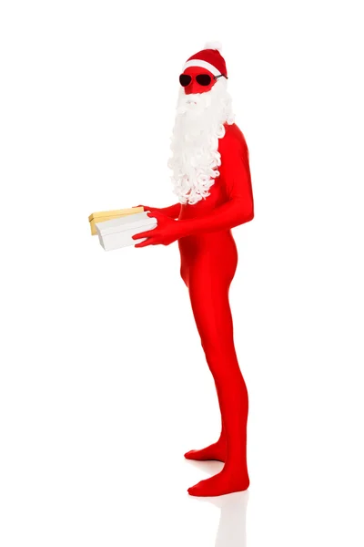 Santa in latex clothing holding gifts — Stock Photo, Image
