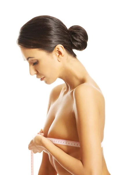 Side view of a nude woman measuring her breast — Stock Photo, Image