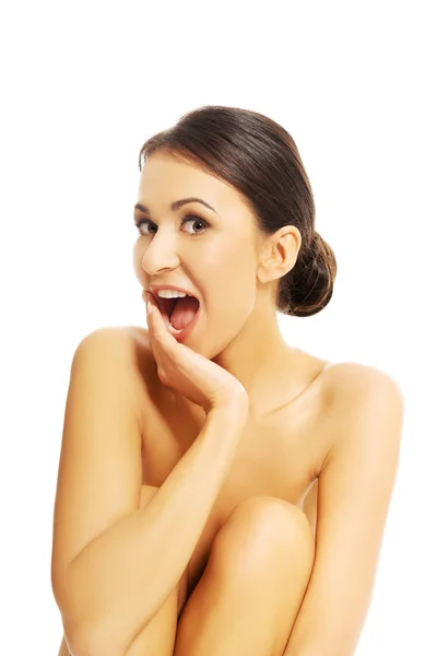 Shocked nude woman sitting with bended knees — Stock Photo, Image