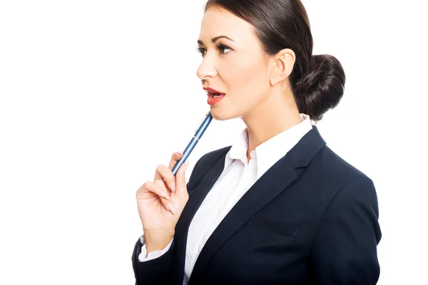 Retrato de una mujer de negocios sosteniendo la pluma bajo la barbilla — Foto de Stock