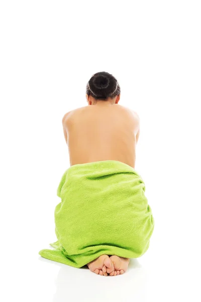 Back view woman sitting wrapped in towel — Stock Photo, Image